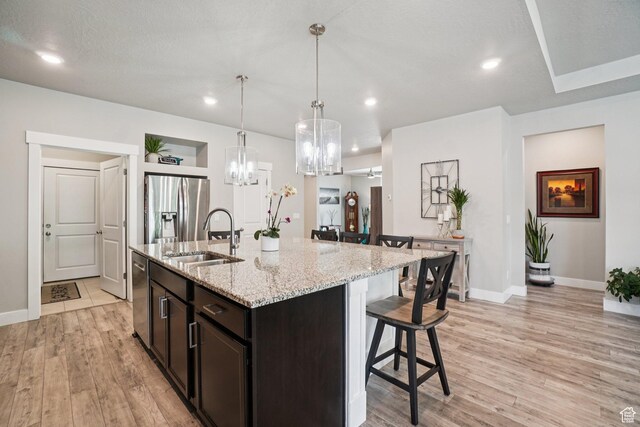 287 S Hayes Well Ln, Saratoga Springs, UT 84045 - kitchen with stainless steel appliances, a kitchen bar, a chandelier, light wood-style flooring, and recessed lighting