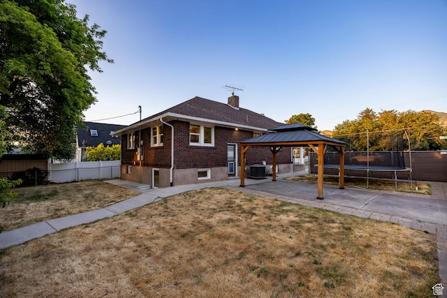 3076 S Melbourne St, Millcreek, UT 84106 - back of house featuring a trampoline, a gazebo, brick siding, a patio, and a chimney