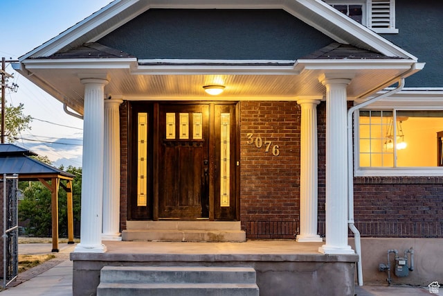 3076 S Melbourne St, Millcreek, UT 84106 - doorway to property featuring covered porch and brick siding