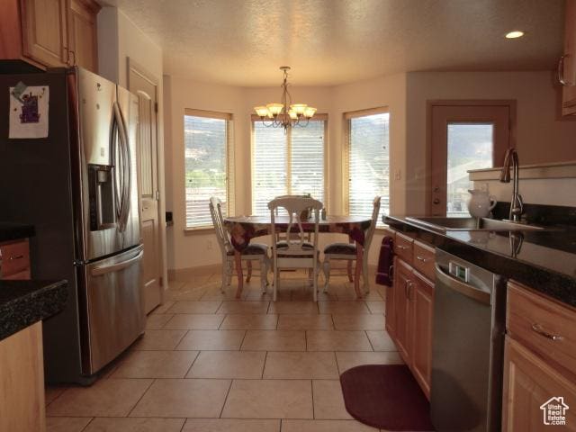 320 S 1125 W, Parowan, UT 84761 - kitchen featuring stainless steel appliances, dark countertops, a chandelier, decorative light fixtures, and light tile patterned flooring