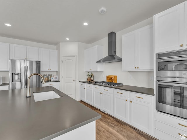 13249 S Shearing Cv, Herriman, UT 84096 - kitchen featuring wall chimney exhaust hood, stainless steel appliances, dark countertops, recessed lighting, and light wood-style floors