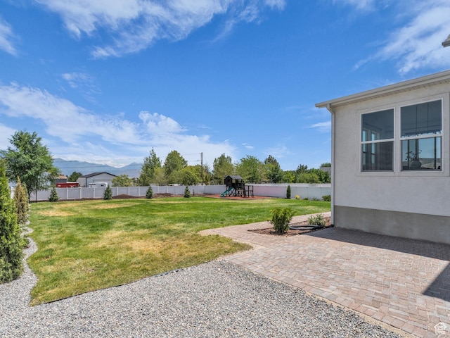 13249 S Shearing Cv, Herriman, UT 84096 - fenced backyard with a playground, a mountain view, and a patio