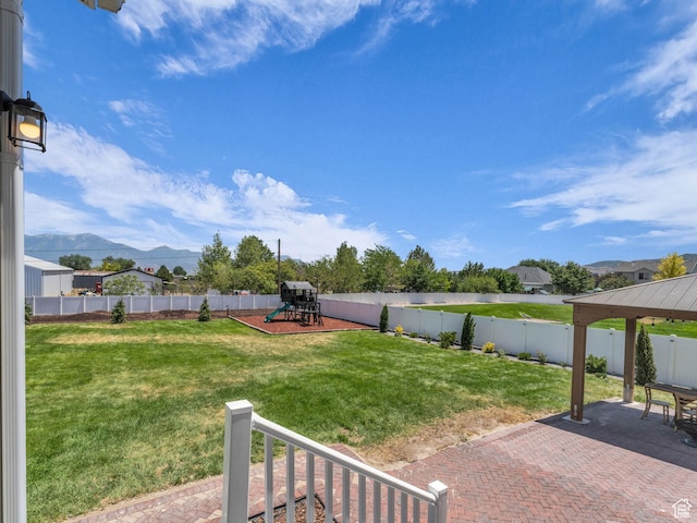 13249 S Shearing Cv, Herriman, UT 84096 - fenced backyard featuring a playground, a mountain view, and a patio