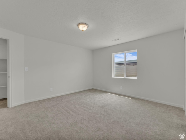 13249 S Shearing Cv, Herriman, UT 84096 - unfurnished bedroom with carpet flooring, a textured ceiling, and a walk in closet