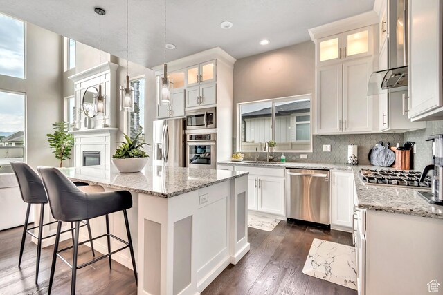 11531 S 840 W, Draper, UT 84020 - kitchen with appliances with stainless steel finishes, wall chimney exhaust hood, a kitchen island, backsplash, and white cabinets