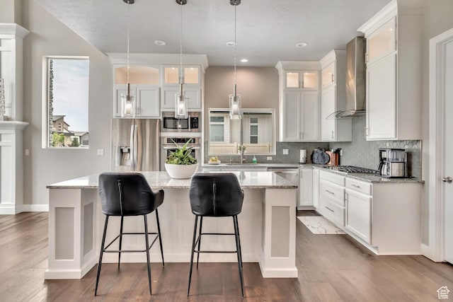 11531 S 840 W, Draper, UT 84020 - kitchen with wall chimney exhaust hood, stainless steel appliances, a kitchen island, backsplash, and white cabinets