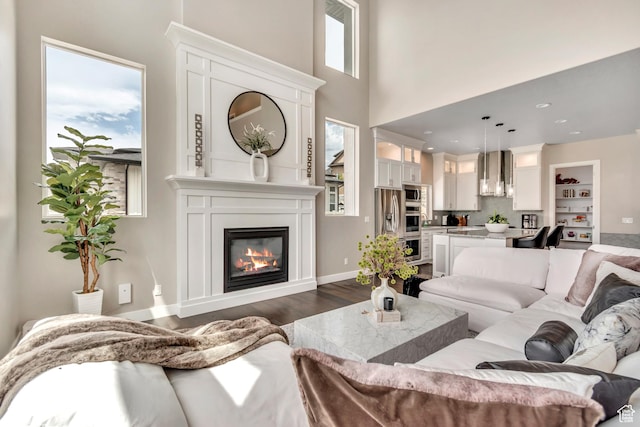 11531 S 840 W, Draper, UT 84020 - living area with dark wood-type flooring, a large fireplace, and a towering ceiling