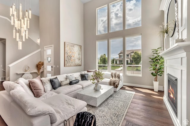 11531 S 840 W, Draper, UT 84020 - living area with a towering ceiling, wood finished floors, a glass covered fireplace, and a chandelier