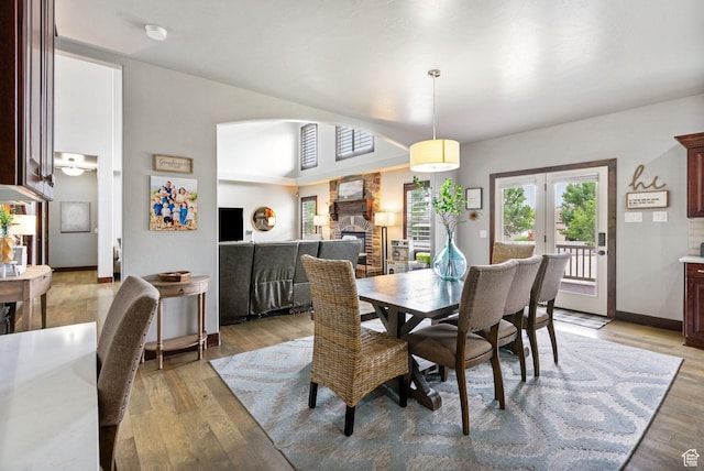 5584 N Gentle Breeze Ct, Stansbury Park, UT 84074 - dining space with light wood-type flooring, a fireplace, and arched walkways