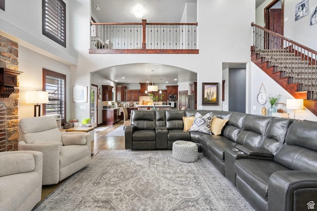 5584 N Gentle Breeze Ct, Stansbury Park, UT 84074 - living room with a high ceiling, light wood finished floors, and stairway