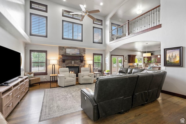 5584 N Gentle Breeze Ct, Stansbury Park, UT 84074 - living area with ceiling fan, a fireplace, a high ceiling, and wood finished floors