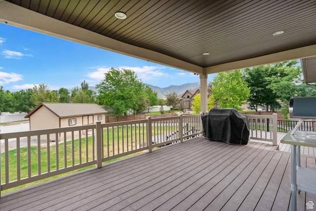 5584 N Gentle Breeze Ct, Stansbury Park, UT 84074 - wooden deck featuring an outbuilding, grilling area, a fenced backyard, and a mountain view