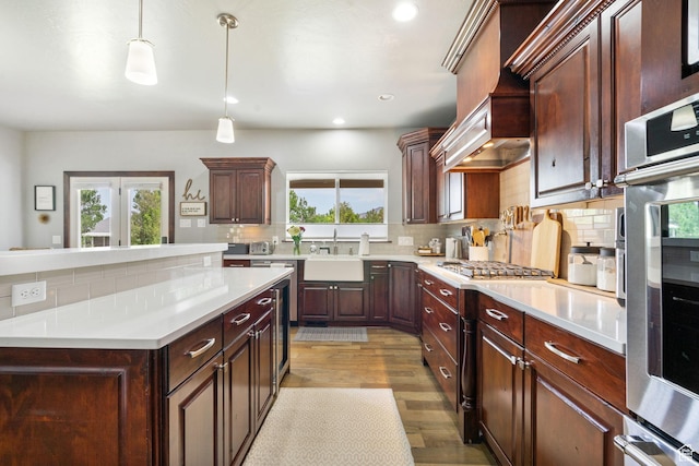 5584 N Gentle Breeze Ct, Stansbury Park, UT 84074 - kitchen featuring decorative backsplash, light countertops, light wood-type flooring, custom range hood, and recessed lighting