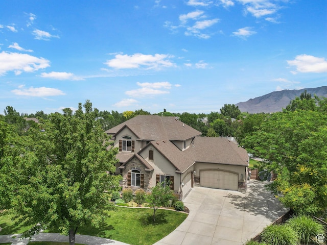5584 N Gentle Breeze Ct, Stansbury Park, UT 84074 - french provincial home with an attached garage, stone siding, stucco siding, concrete driveway, and a front lawn