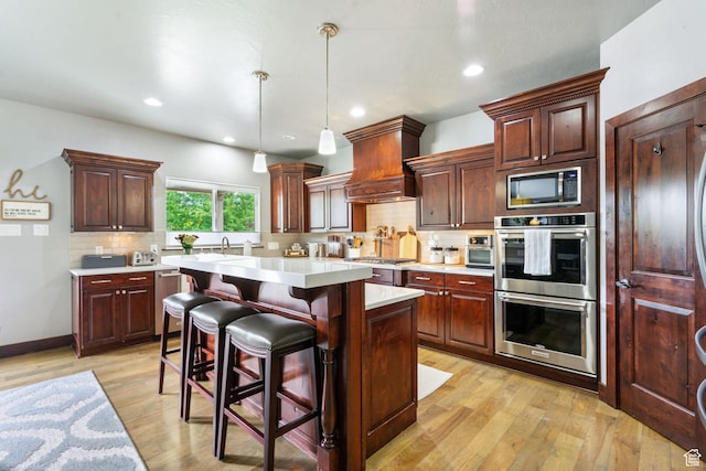 5584 N Gentle Breeze Ct, Stansbury Park, UT 84074 - kitchen featuring appliances with stainless steel finishes, custom range hood, light countertops, tasteful backsplash, and a center island