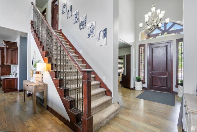 5584 N Gentle Breeze Ct, Stansbury Park, UT 84074 - foyer entrance featuring a towering ceiling, light wood-style flooring, stairs, and a chandelier