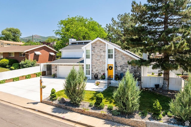 534 E 1400th St S, Bountiful, UT 84010 - mid-century home featuring stone siding, concrete driveway, an attached garage, and a mountain view