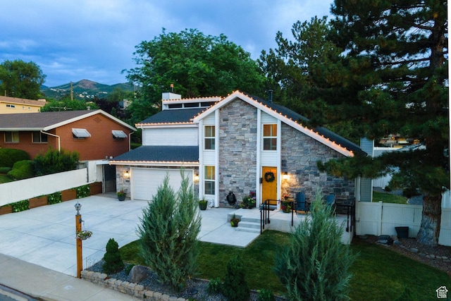 534 E 1400th St S, Bountiful, UT 84010 - view of front of house featuring stone siding, concrete driveway, an attached garage, and a mountain view