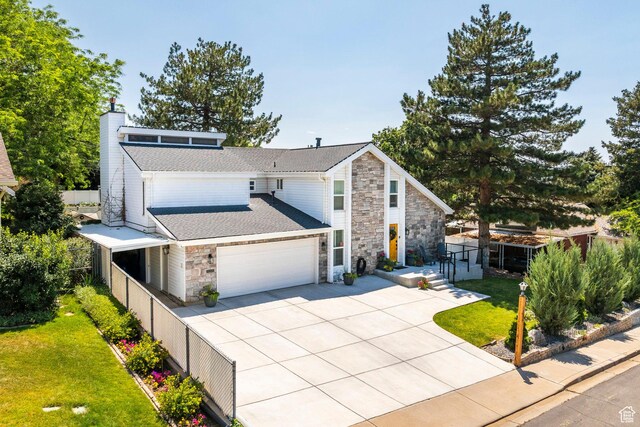 534 E 1400th St S, Bountiful, UT 84010 - view of front facade featuring stone siding, concrete driveway, an attached garage, a chimney, and a shingled roof