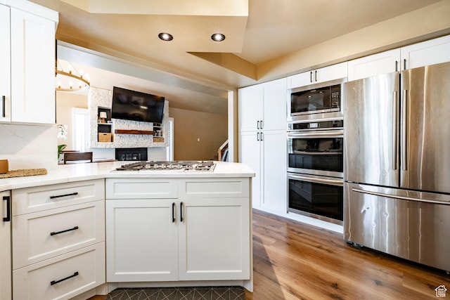 534 E 1400th St S, Bountiful, UT 84010 - kitchen featuring appliances with stainless steel finishes, white cabinets, a peninsula, wood finished floors, and light countertops