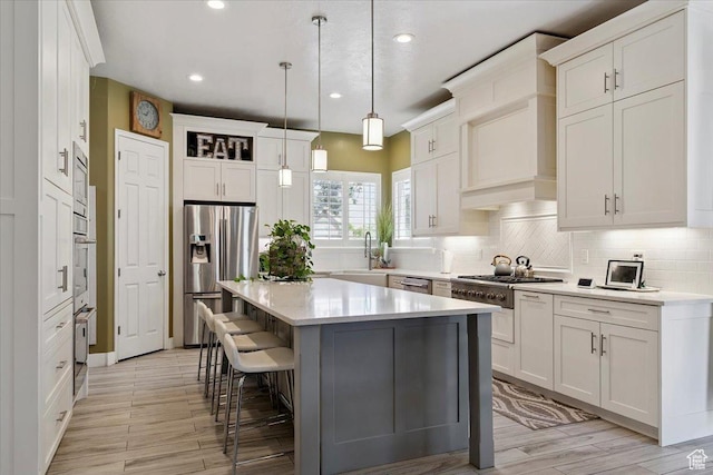 3680 N 2300 E, Layton, UT 84040 - kitchen with appliances with stainless steel finishes, a center island, decorative backsplash, a kitchen breakfast bar, and recessed lighting