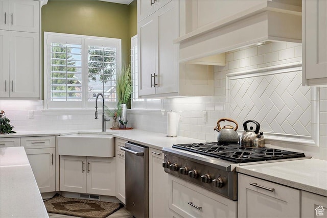 3680 N 2300 E, Layton, UT 84040 - kitchen featuring appliances with stainless steel finishes, backsplash, custom range hood, and white cabinetry