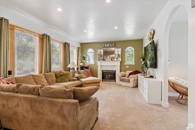 3680 N 2300 E, Layton, UT 84040 - living area with light carpet, a glass covered fireplace, arched walkways, and recessed lighting