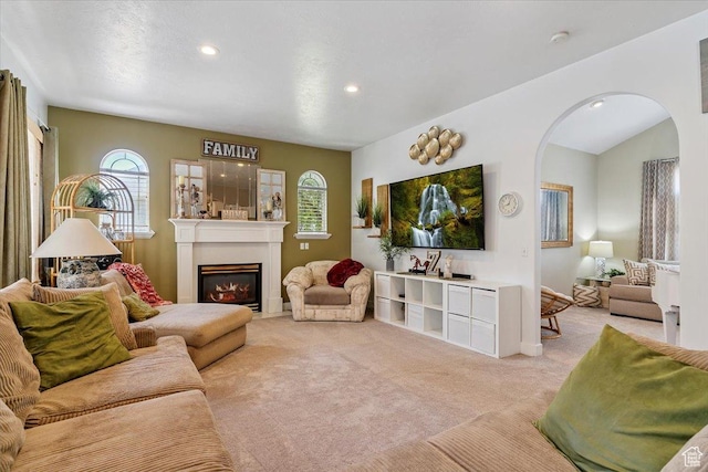 3680 N 2300 E, Layton, UT 84040 - living area with arched walkways, light colored carpet, a glass covered fireplace, and recessed lighting