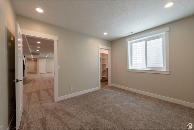 1233 S 2240 E, Heber City, UT 84032 - unfurnished bedroom featuring light colored carpet, recessed lighting, a walk in closet, and a textured ceiling