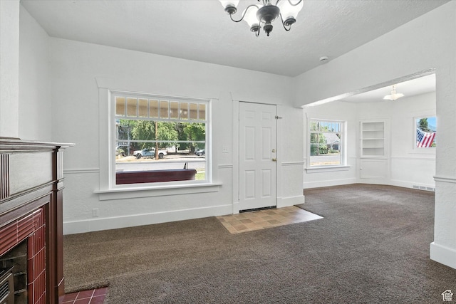 90 W 200 S, Logan, UT 84321 - unfurnished living room featuring a chandelier, carpet, a fireplace, and built in shelves