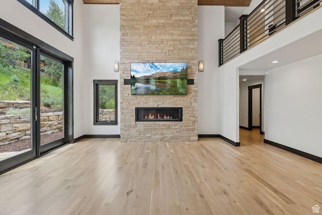 4670 Nelson Ct, Park City, UT 84098 - unfurnished living room with a towering ceiling, a stone fireplace, and wood finished floors