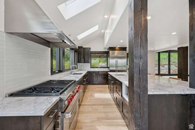 4670 Nelson Ct, Park City, UT 84098 - kitchen with ventilation hood, premium appliances, a skylight, light wood-style flooring, and dark brown cabinets