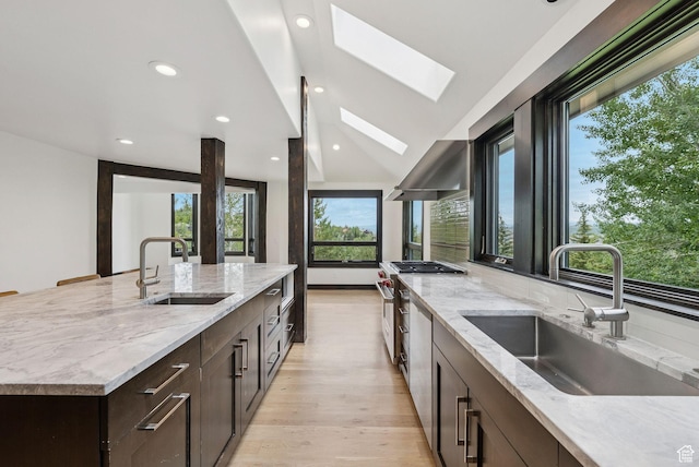 4670 Nelson Ct, Park City, UT 84098 - kitchen featuring a skylight, wall chimney range hood, dark brown cabinets, high end stainless steel range, and light stone counters