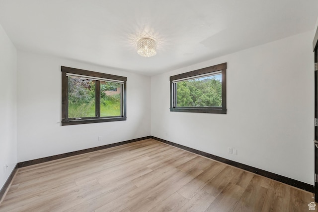 4670 Nelson Ct, Park City, UT 84098 - empty room with healthy amount of natural light, a chandelier, and light wood-style floors
