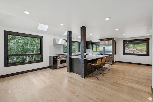 4670 Nelson Ct, Park City, UT 84098 - kitchen with high quality appliances, wall chimney range hood, a skylight, healthy amount of natural light, and recessed lighting