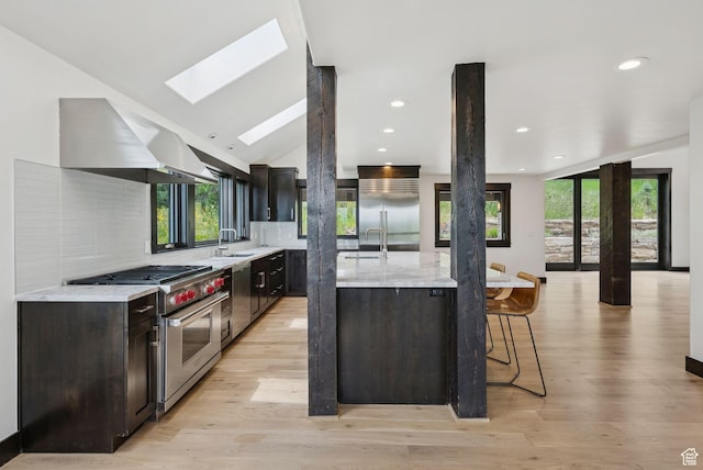4670 Nelson Ct, Park City, UT 84098 - kitchen with premium appliances, island range hood, a skylight, a spacious island, and backsplash