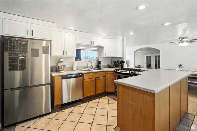 318 W 1300 N, Sunset, UT 84015 - kitchen featuring stainless steel appliances, arched walkways, a peninsula, a ceiling fan, and light countertops