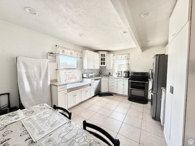 4606 W 5540 S, Kearns, UT 84118 - kitchen with stainless steel appliances, white cabinets, light countertops, a textured ceiling, and glass insert cabinets