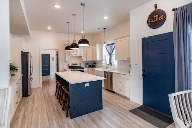 373 W Rendezvous Way N, Garden City, UT 84028 - kitchen featuring appliances with stainless steel finishes, light countertops, a kitchen island, light wood-style floors, and recessed lighting