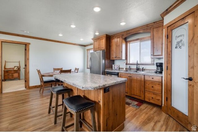 4178 E 5000 S, Vernal, UT 84078 - kitchen featuring freestanding refrigerator, a kitchen island, light wood finished floors, a breakfast bar area, and crown molding