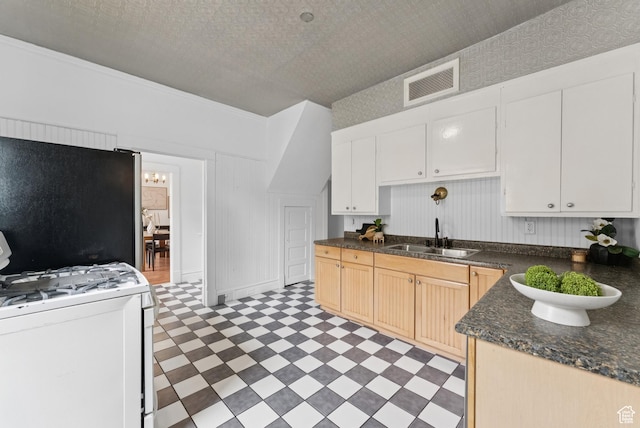 467 S 1300 E, Salt Lake City, UT 84102 - kitchen featuring white range with gas cooktop, light flooring, freestanding refrigerator, and dark countertops