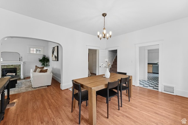467 S 1300 E, Salt Lake City, UT 84102 - dining space with stairway, a chandelier, light wood-style flooring, and arched walkways