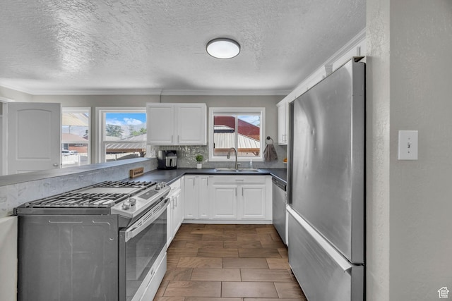 4682 S 475 W, Washington Terrace, UT 84405 - kitchen with appliances with stainless steel finishes, dark countertops, white cabinets, a textured ceiling, and decorative backsplash