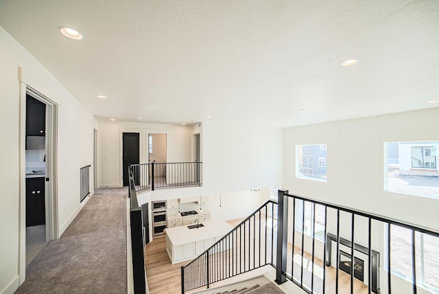 10942 S Samoa Dune Dr, South Jordan, UT 84009 - hallway with an upstairs landing, recessed lighting, light carpet, and light wood-type flooring