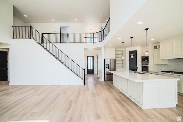 10942 S Samoa Dune Dr, South Jordan, UT 84009 - kitchen with appliances with stainless steel finishes, light countertops, a large island with sink, light wood-type flooring, and recessed lighting