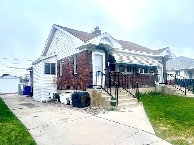 7659 S Lincoln St, Midvale, UT 84047 - view of front of house with a chimney, a front yard, driveway, and brick siding