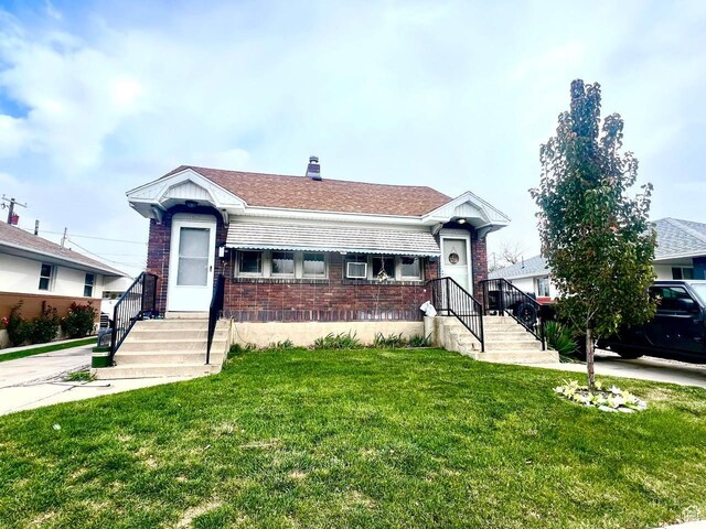 7659 S Lincoln St, Midvale, UT 84047 - view of front of home with brick siding, a front lawn, and a chimney