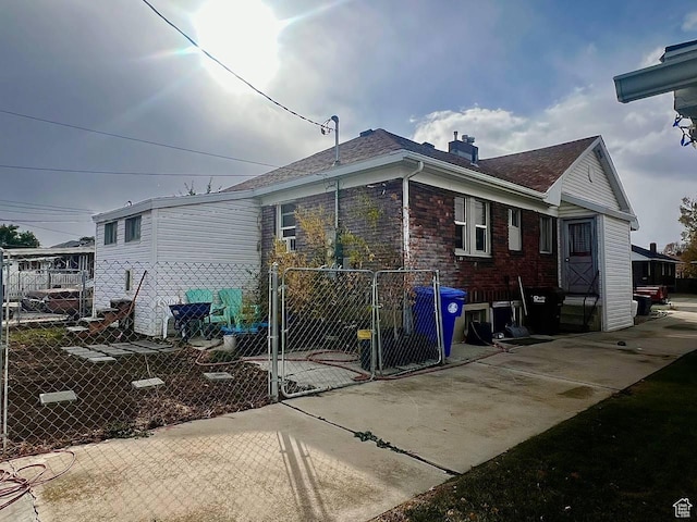 7659 S Lincoln St, Midvale, UT 84047 - view of side of property with a gate, a chimney, and roof with shingles