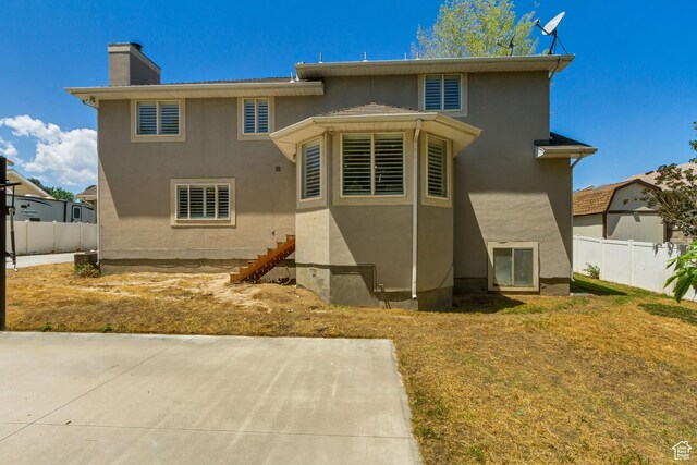 6063 S Kamas Dr W, Taylorsville, UT 84129 - rear view of property featuring a chimney, a patio area, stucco siding, and stairway