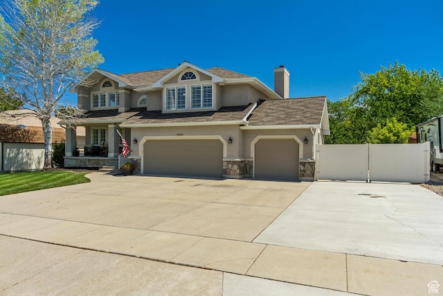 6063 S Kamas Dr W, Taylorsville, UT 84129 - view of front of property featuring concrete driveway, stucco siding, a chimney, stone siding, and roof with shingles